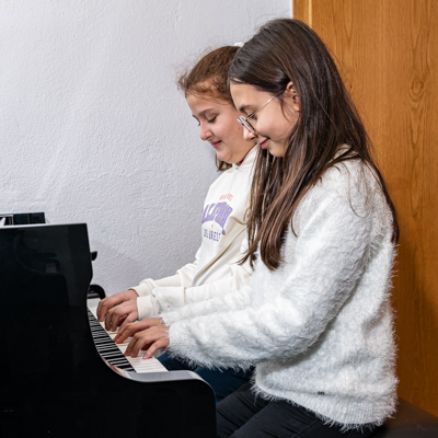Zwei Kinder an einem Klavier